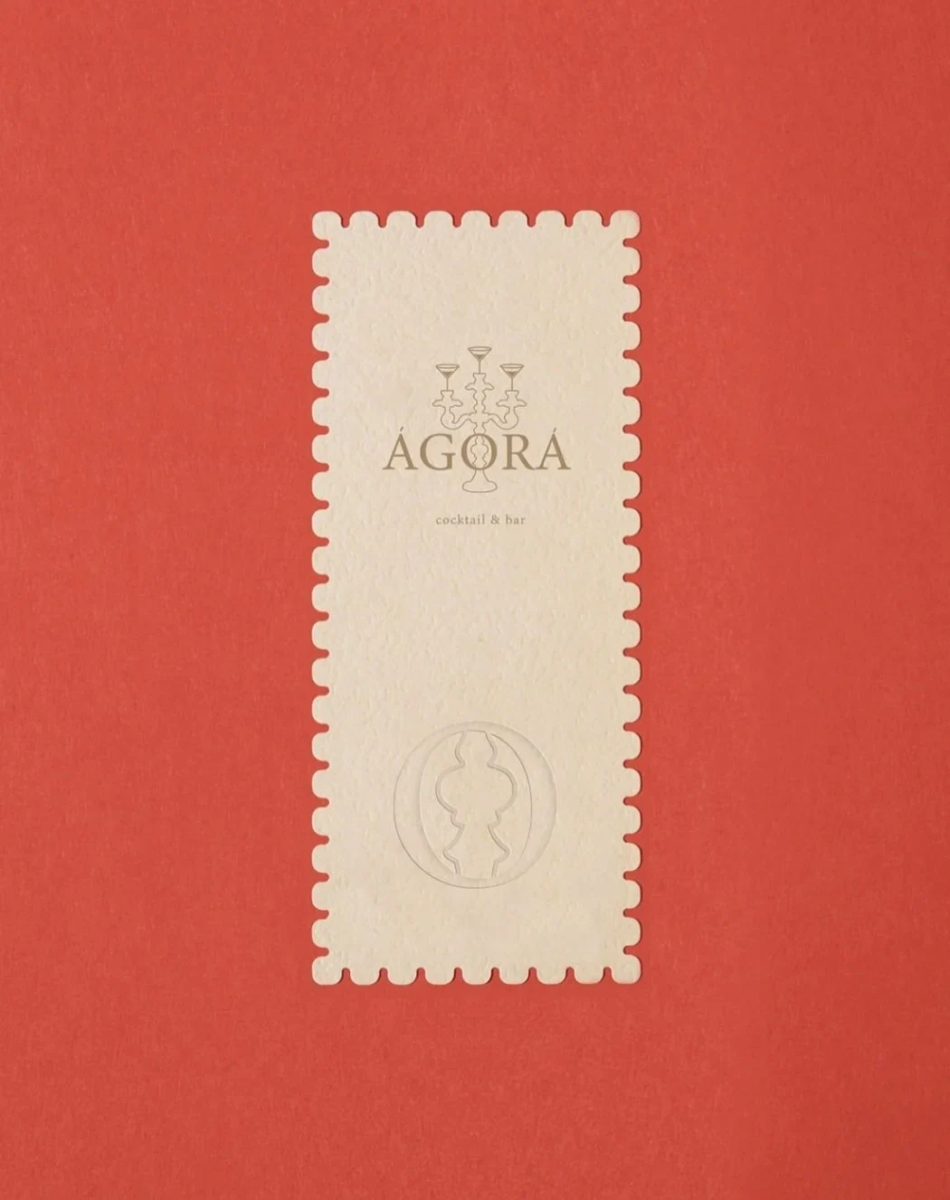AGORA cream stamp-shaped label with serif typography and a classical profile on red