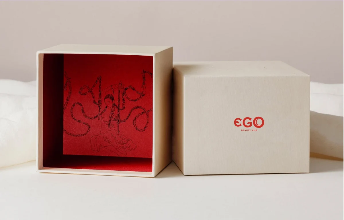 EGO ivory presentation box with a red interior and symbolic illustration