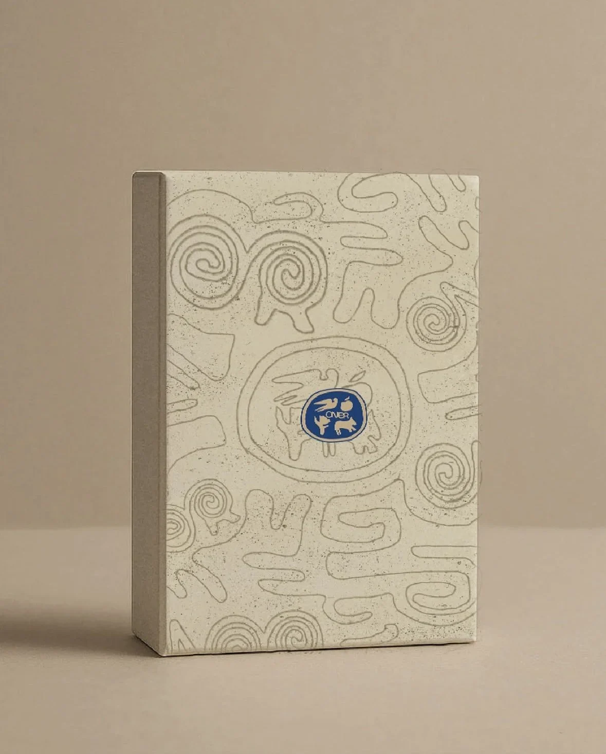 ÖNER sand-colored cover with drawn symbols and a blue-and-gold emblem