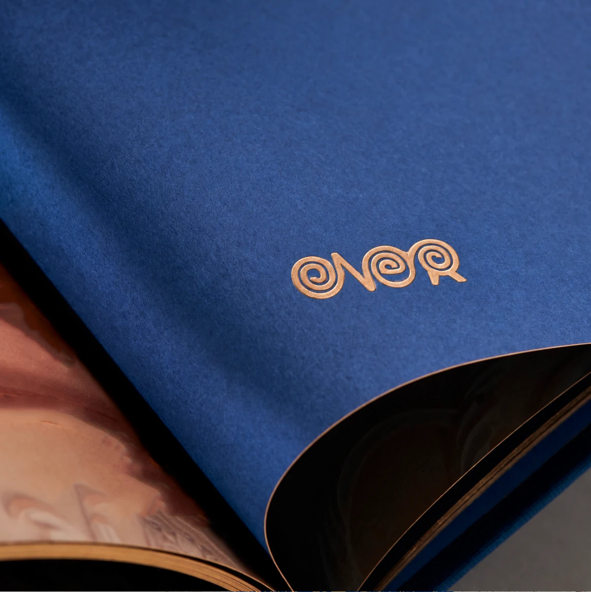 ÖNER gold wordmark on folded cobalt blue material