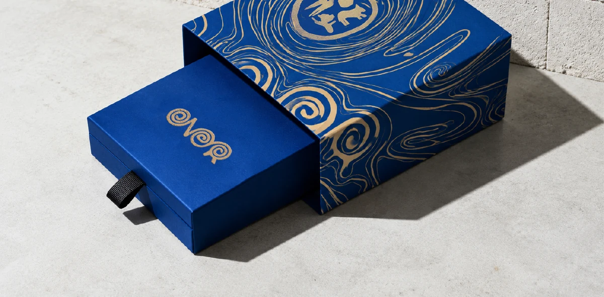 ÖNER blue presentation boxes with gold wordmarks and flowing patterns